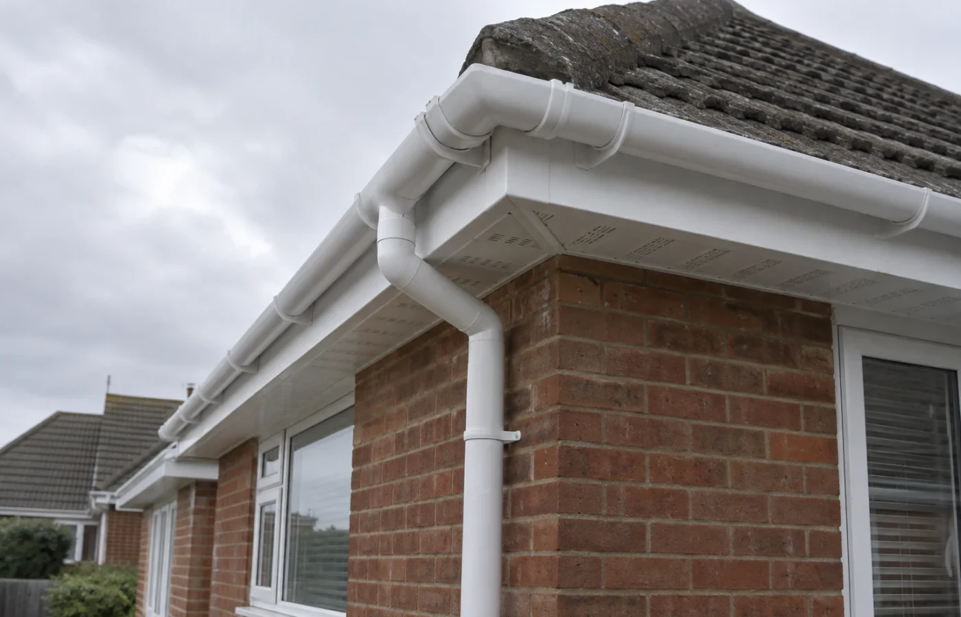 White uPVC fascia, ventilated soffit and guttering fitted to a red-brick home