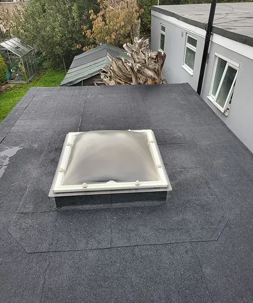 New felt flat roof with a polycarbonate dome rooflight fitted over a garden room extension