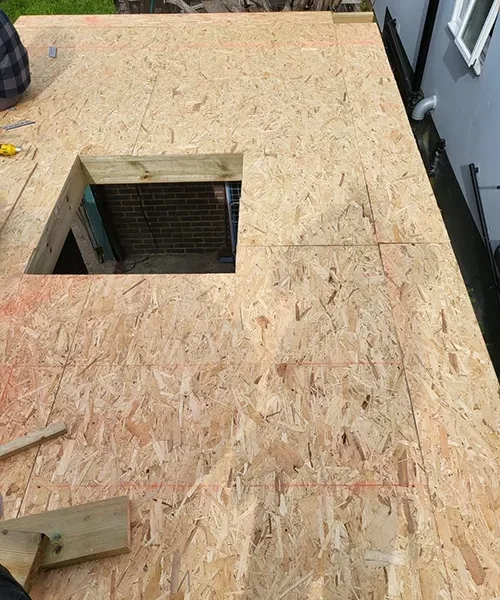 New OSB roof decking on a flat roof extension with a timber-framed opening formed for a rooflight