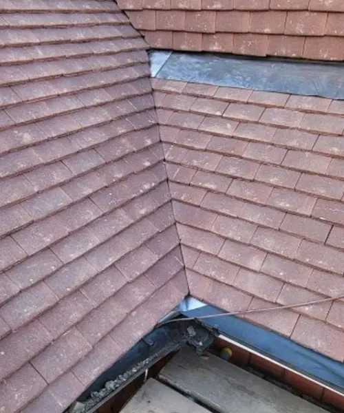 Tiled roof hip and valley showing neat coursing and hand-cut tiles