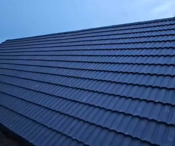 New dark blue-grey concrete tile roof laid in neat diagonal courses under a clear sky